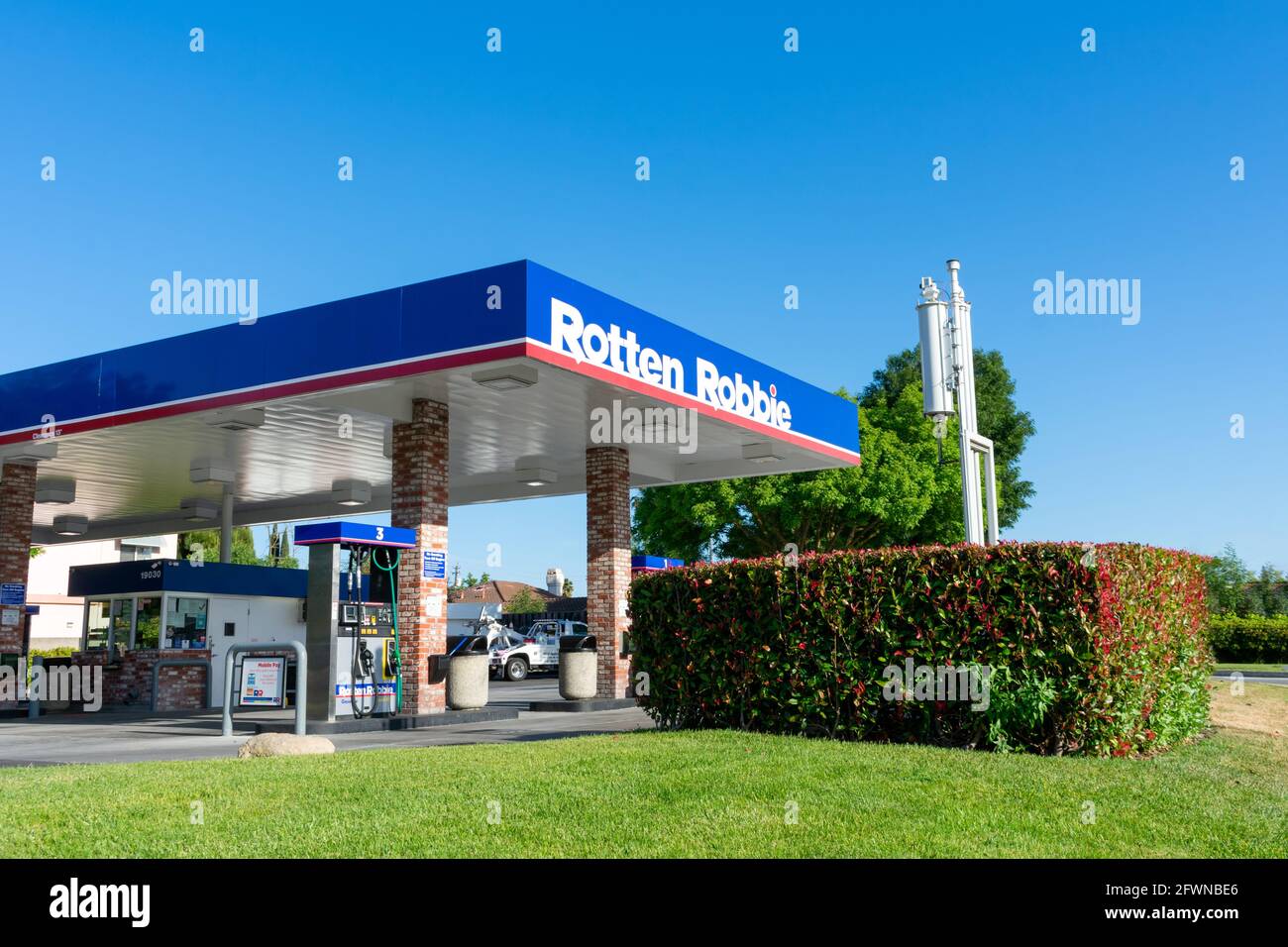 Rotten Robbie gas station exterior under blue sky. - San