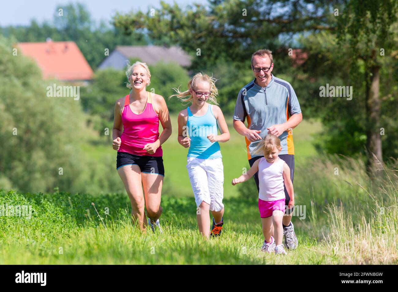 Parents with two children sport running outdoors Stock Photo