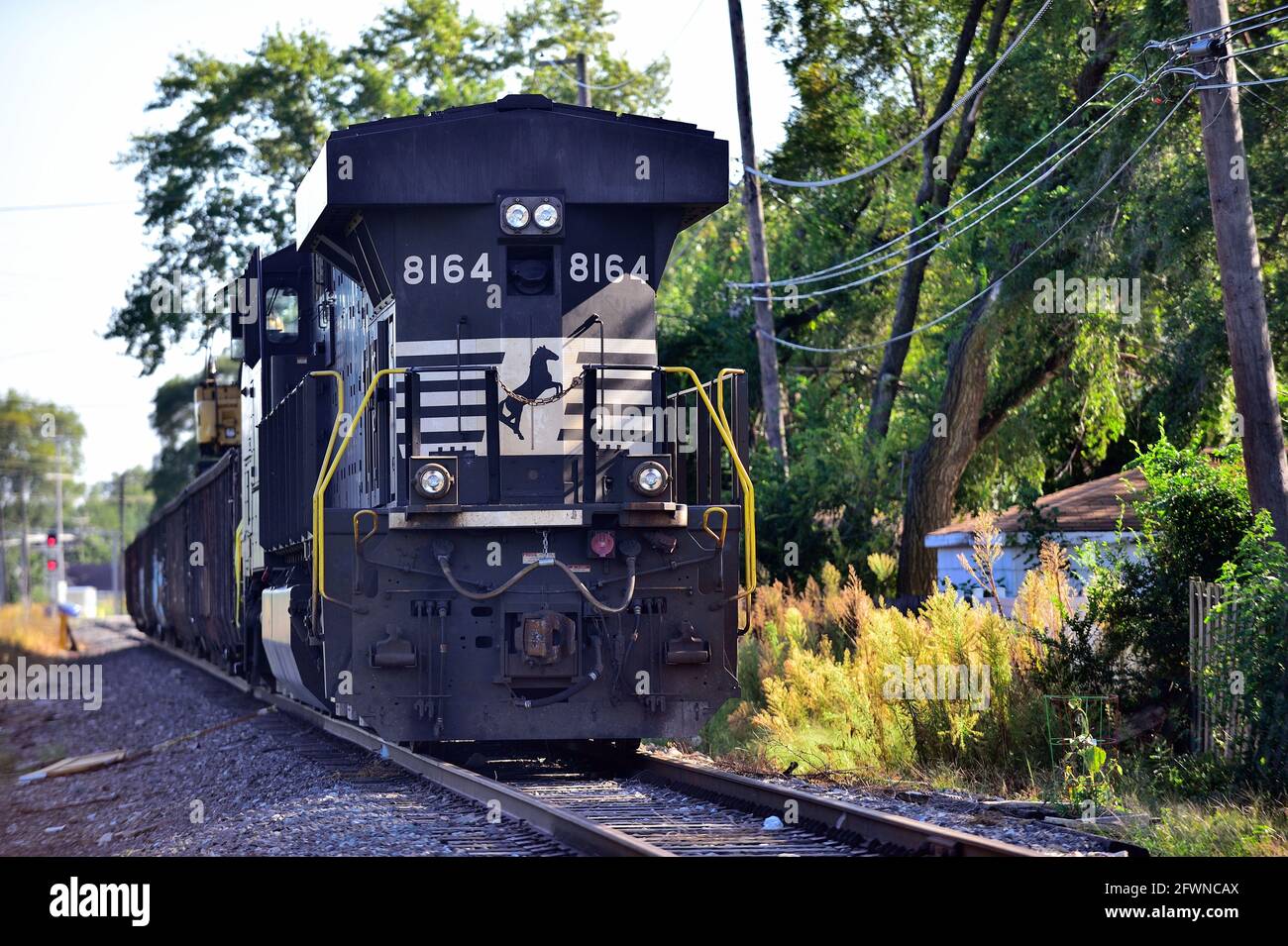 Chicago, Illinois, USA. A Norfolk Southern diesel locomotive parked on a branch line track the runs between and parallel to two residential blocks of Stock Photo
