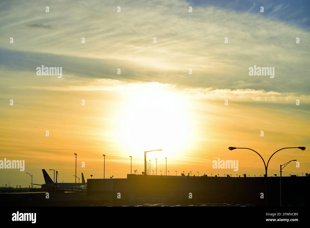 Chicago, Illinois, USA. The sun setting beyond the gates and terminals at O'Hare International Airport on a busy Christmas Eve. Stock Photo