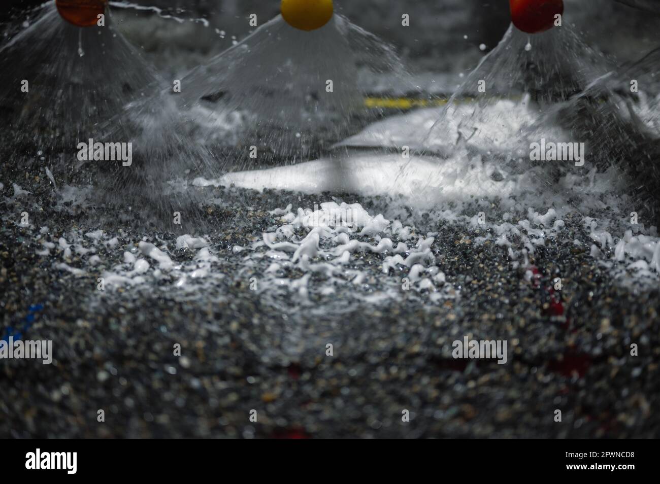 Vibrating screen, ore washing with liquid. Lots of small stones on the surface of the sieve Stock Photo