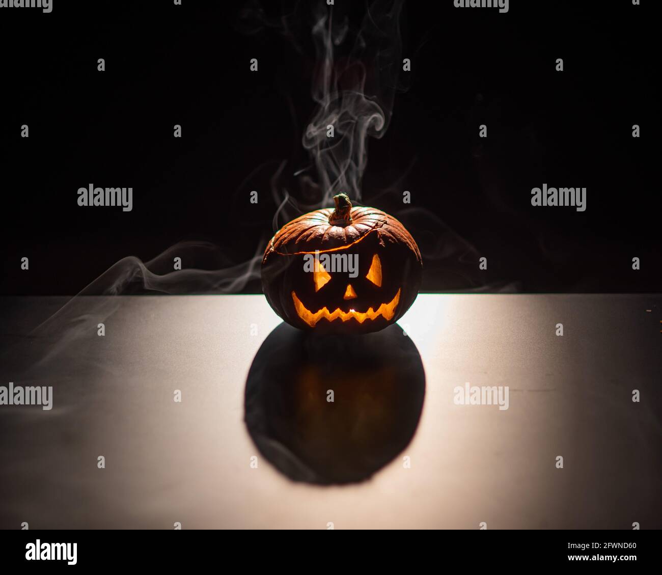 Halloween, orange pumpkin with a scary luminous face on a dark ...