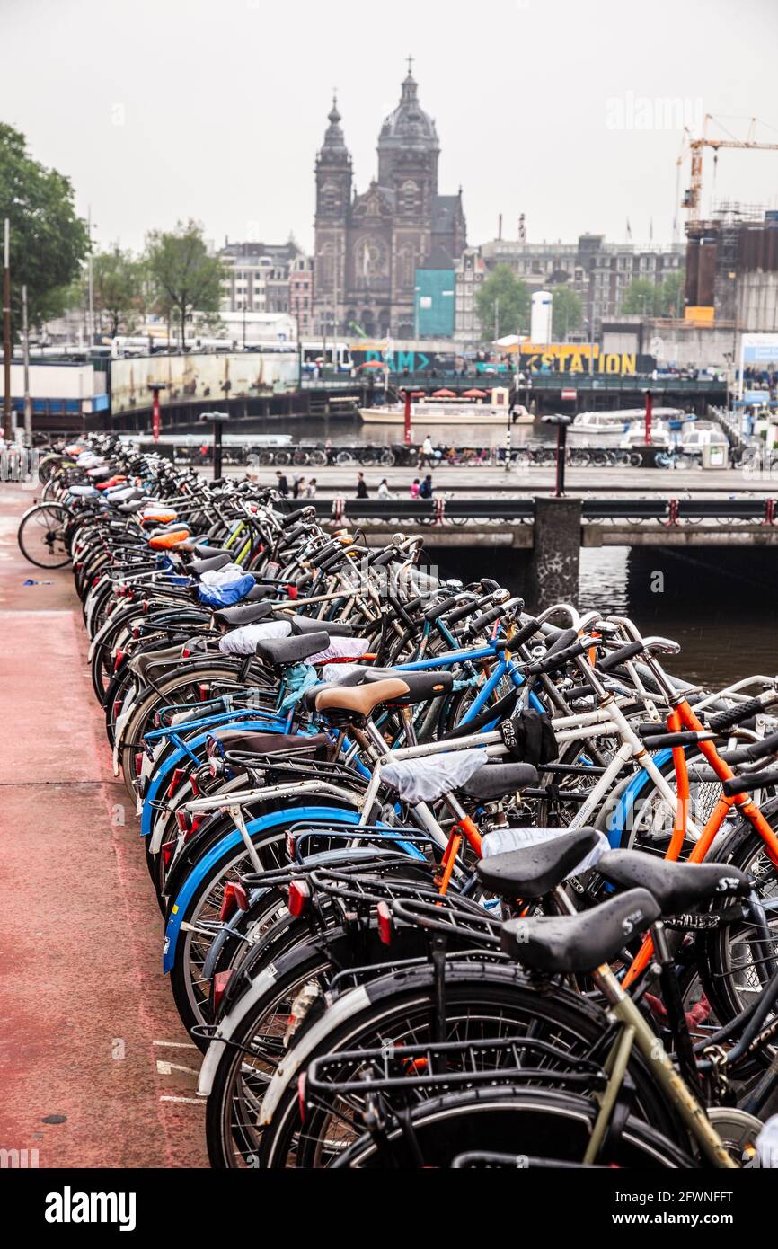 amsterdam commuter train station parking lot showing bicycle healthy lifestyle culture minimising fossil fuel usage Stock Photo