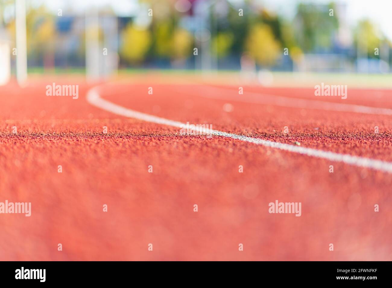 Red plastic track in the outdoor track and field stadium.Closeup. Stock Photo