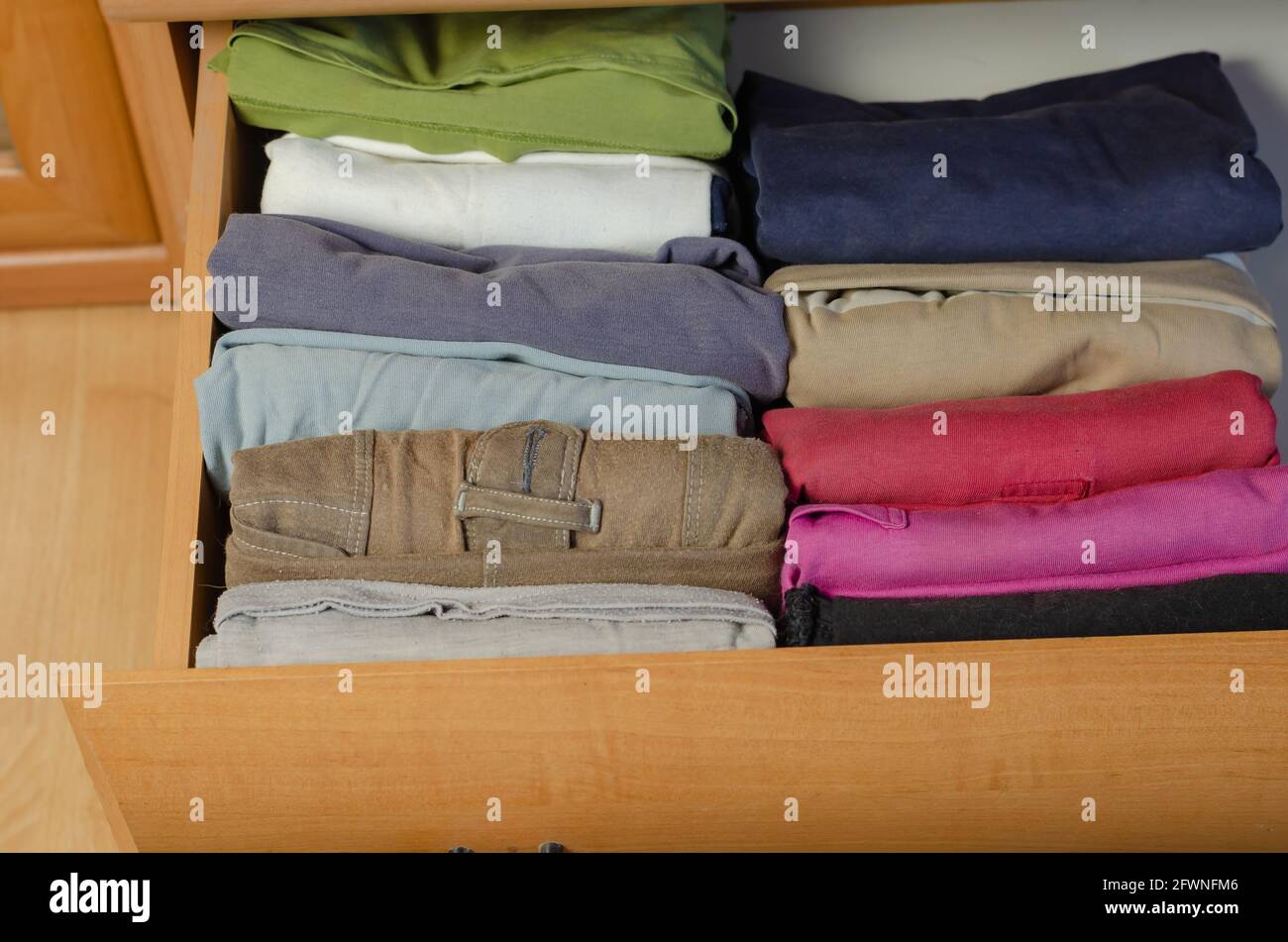 Concept Vertical Japanese clothes storage system. Multicolored shirts