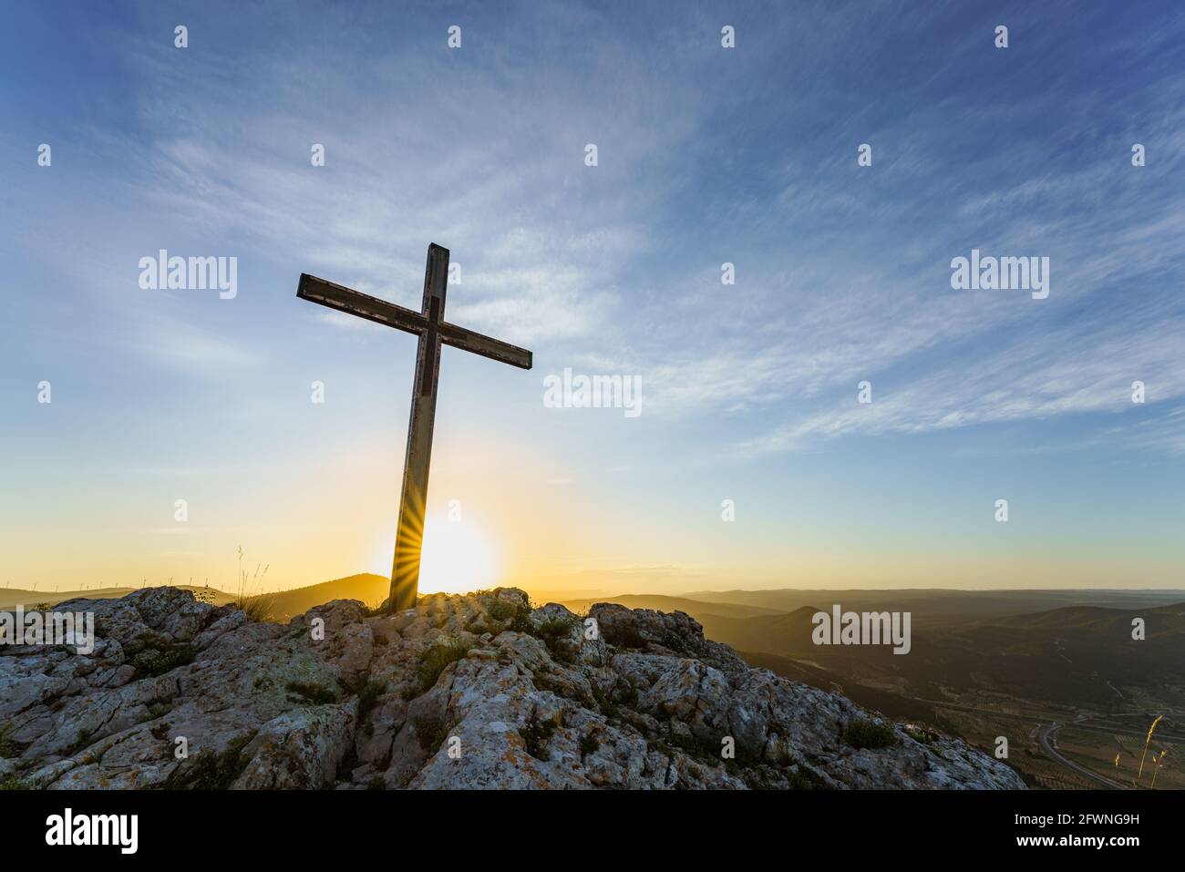 Christian symbol, Wooden Catholic cross on the top of a mountain at sunrise. Stock Photo