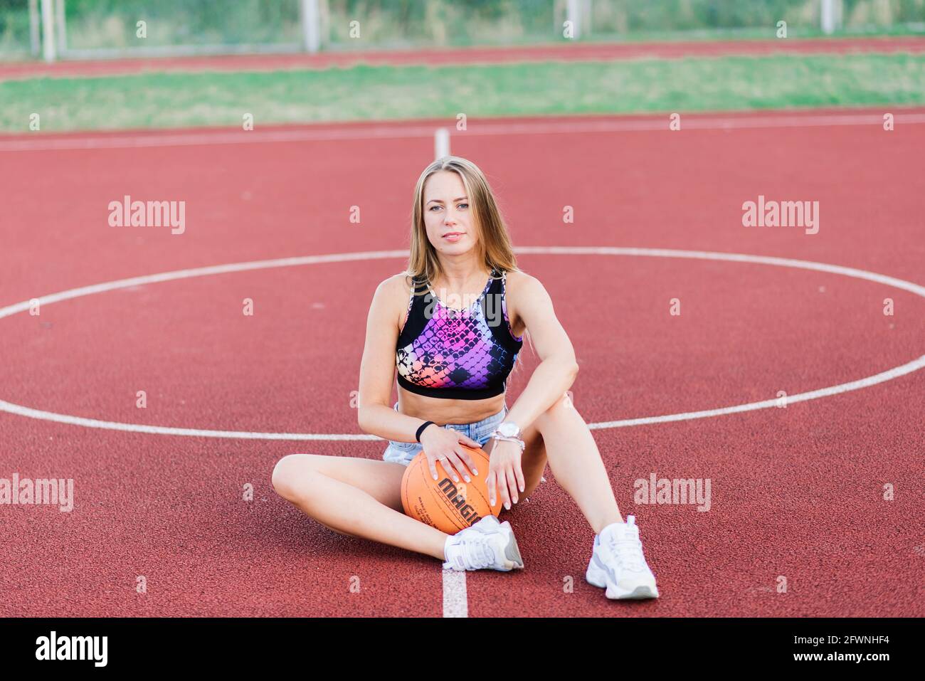Young woman with basketball on an outdoor basketball court Stock Photo ...