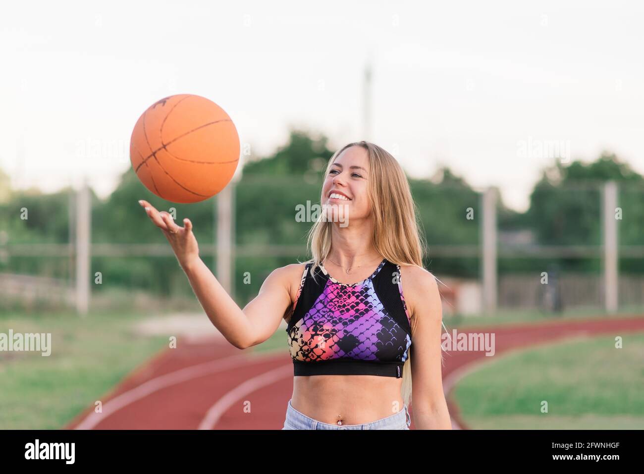 Young woman with basketball on an outdoor basketball court Stock Photo ...