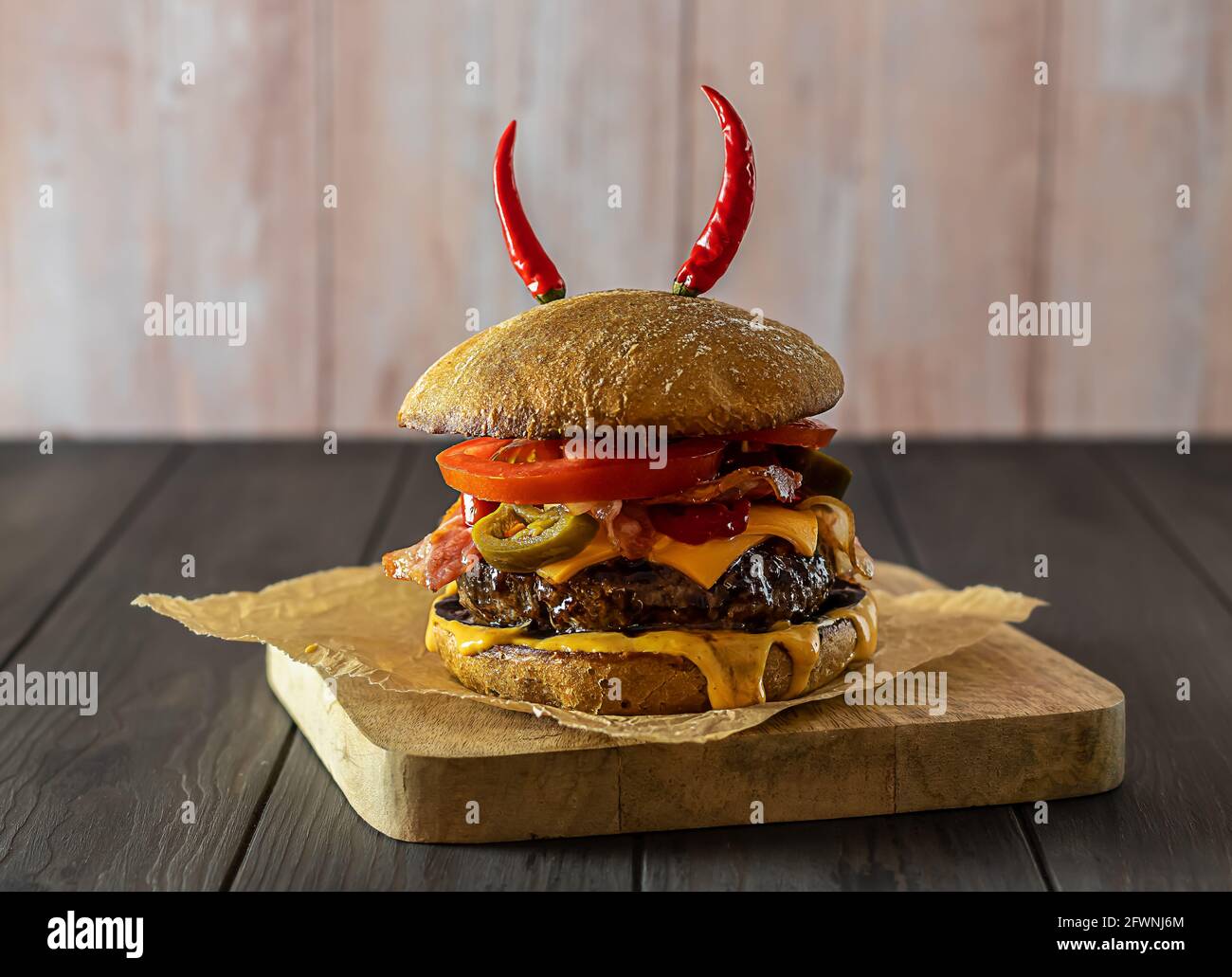 Delicious craft beef burger with jalapenos, cheese, bacon, and whole wheat bun.  Stock Photo