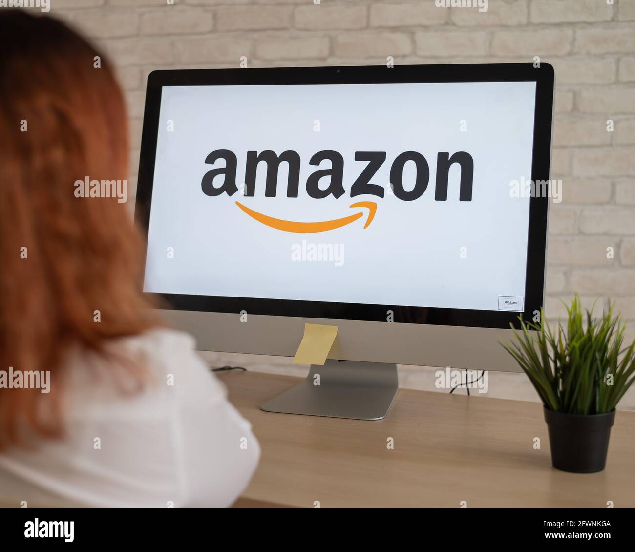 16.09.2020 Russian, Novosibirsk: Woman sitting in front of computer with amazon logo on screen. Stock Photo