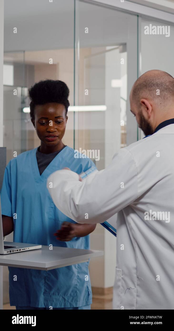 Practitioner nurse in medical uniform typing recovering treatment on