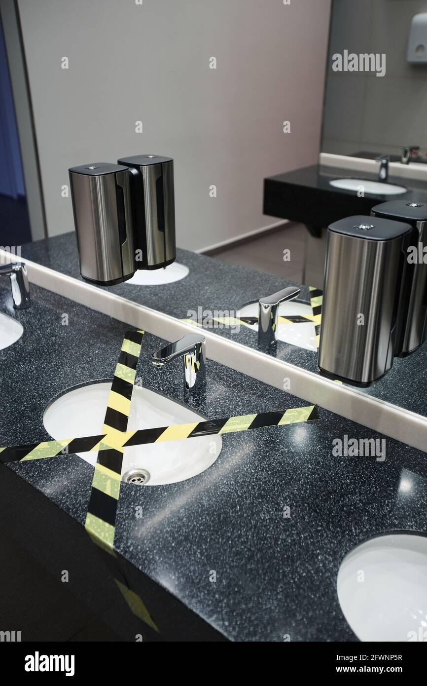 Vertical background image of public restroom with sink taped off for