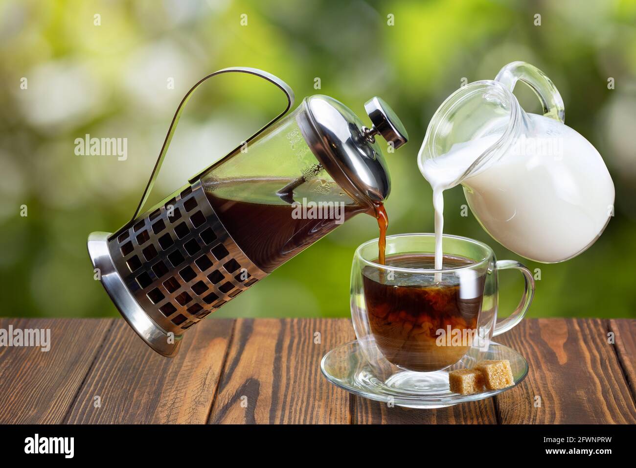 coffee and cream pouring into glass cup Stock Photo