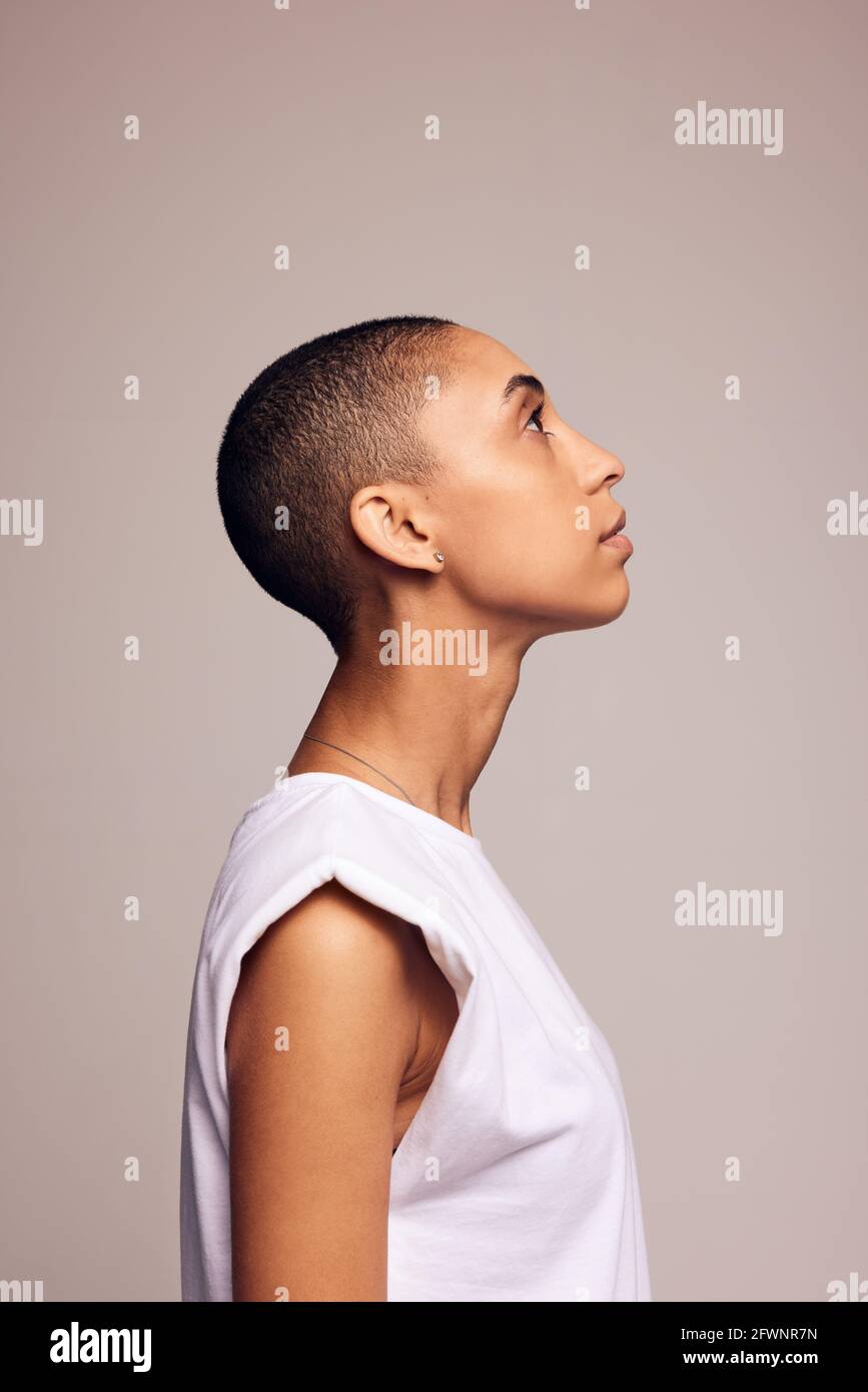 Side view of a female in casuals with shaved head. Androgynous woman