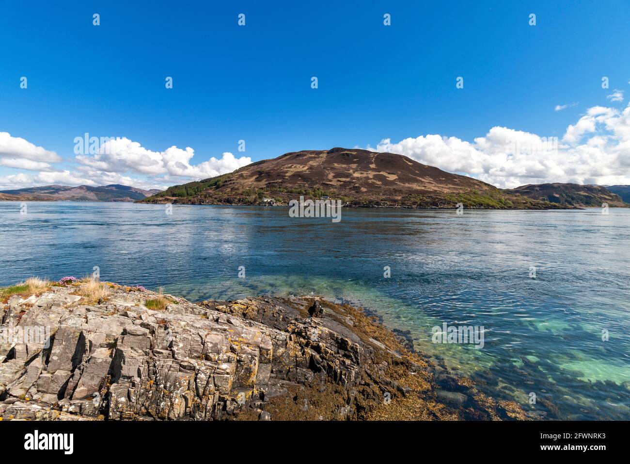GLENELG HIGHLAND SCOTLAND A VIEW FROM SKYE ACROSS THE LIMPID STRAITS OF KYLE RHEA TOWARDS THE FERRY AND FERRY SLIPWAY ON THE MAINLAND Stock Photo