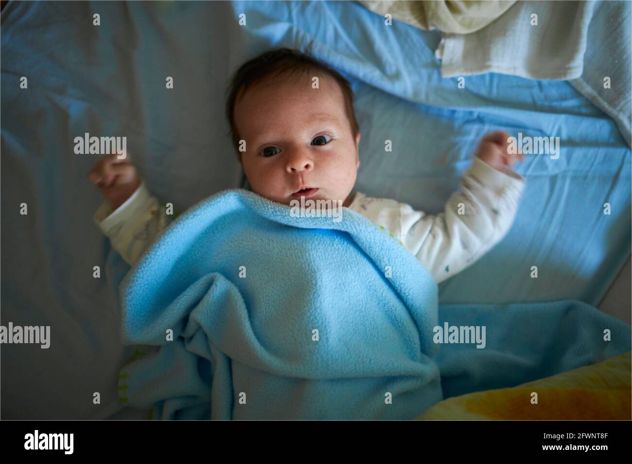 Playful newborn baby in a bed Stock Photo