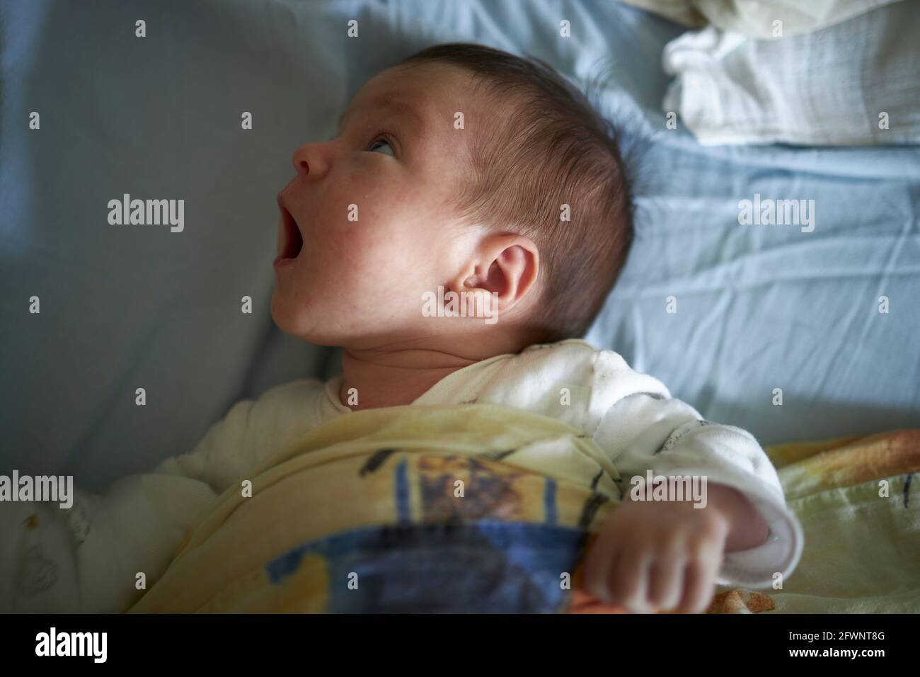 Playful baby searching her surroundings Stock Photo