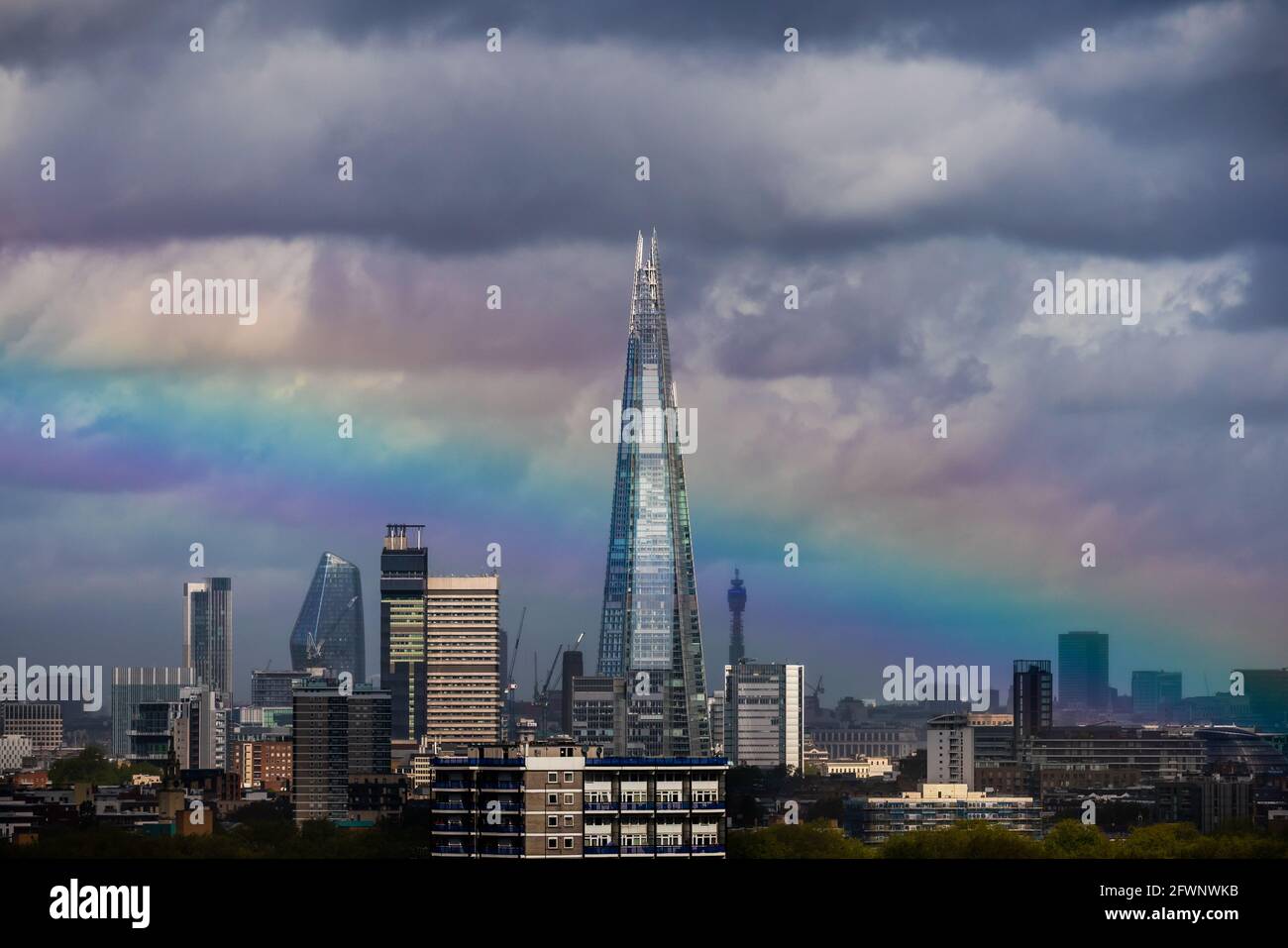 London, UK. 24th May, 2021. UK Weather: A massive rainbow breaks over The Shard skyscraper building after a brief morning rainstorm. Credit: Guy Corbishley/Alamy Live News Stock Photo