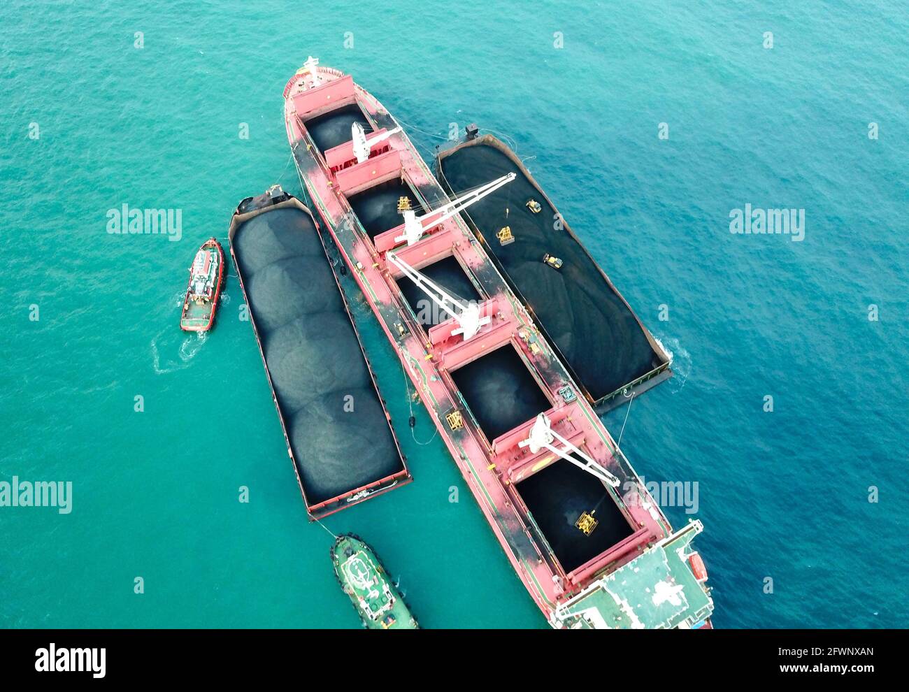 Transporting coal from the barge to the mother vessel aerial view Stock