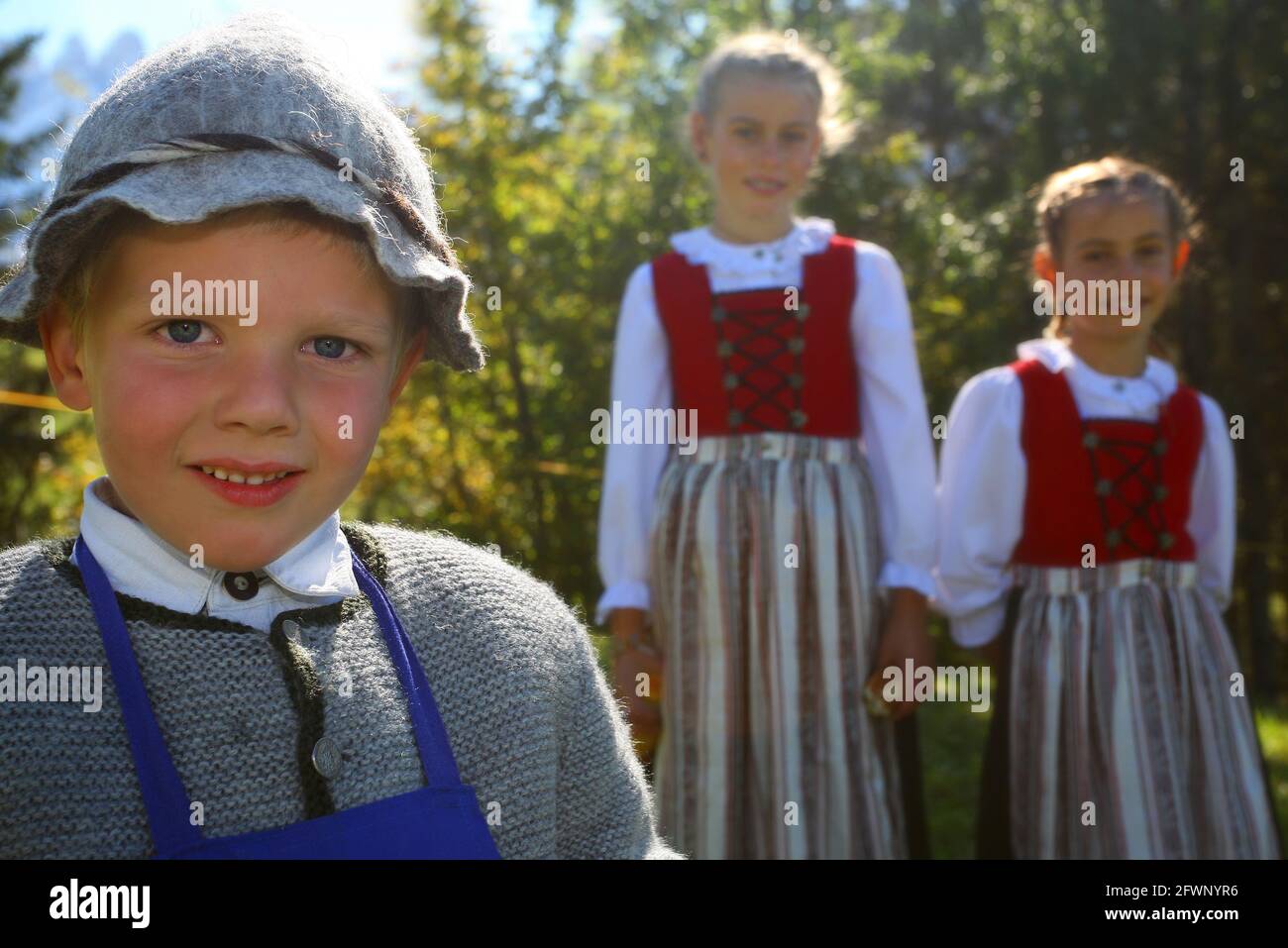 Junge mit Tracht und Hut und Mädchen  mit Tracht und Dirndl in Villnöß in St. Magdalena beim Speckfest und Trachtenfest in den Dolomiten in Südtirol Stock Photo