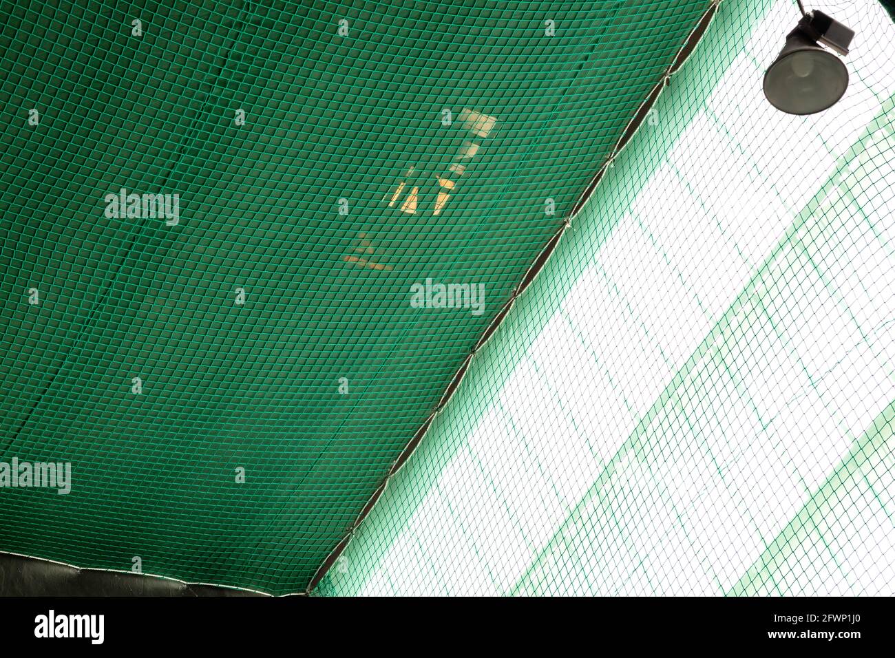 a regulatory safety net of color green, placed under roof to prevent the risk of falls during the works Stock Photo