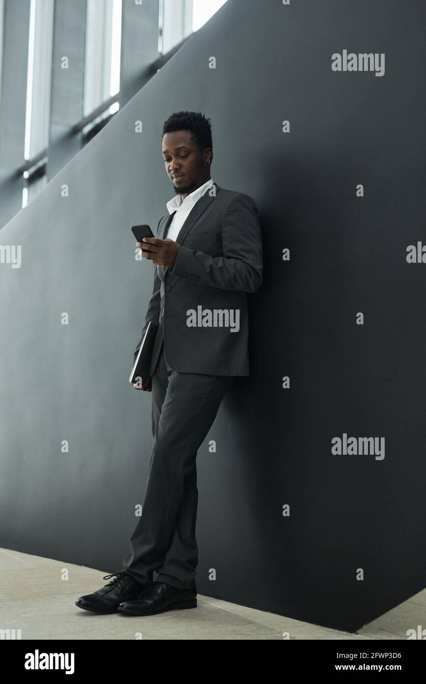 Graphic full length portrait of confident African-American businessman ...