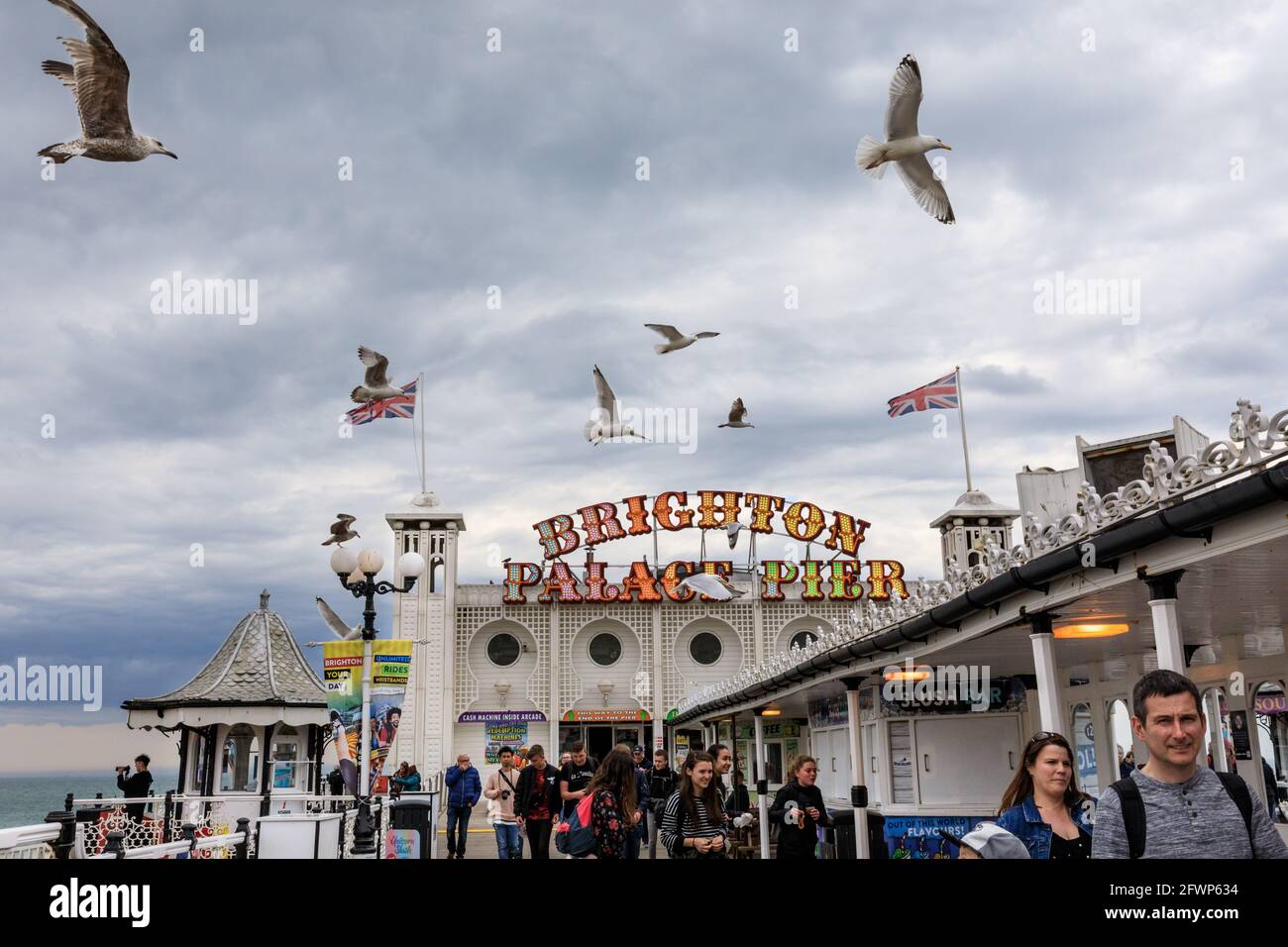 People and seagulls on Brighton Palace Pier, stormy day, Brighton, East Sussex, England, UK Stock Photo