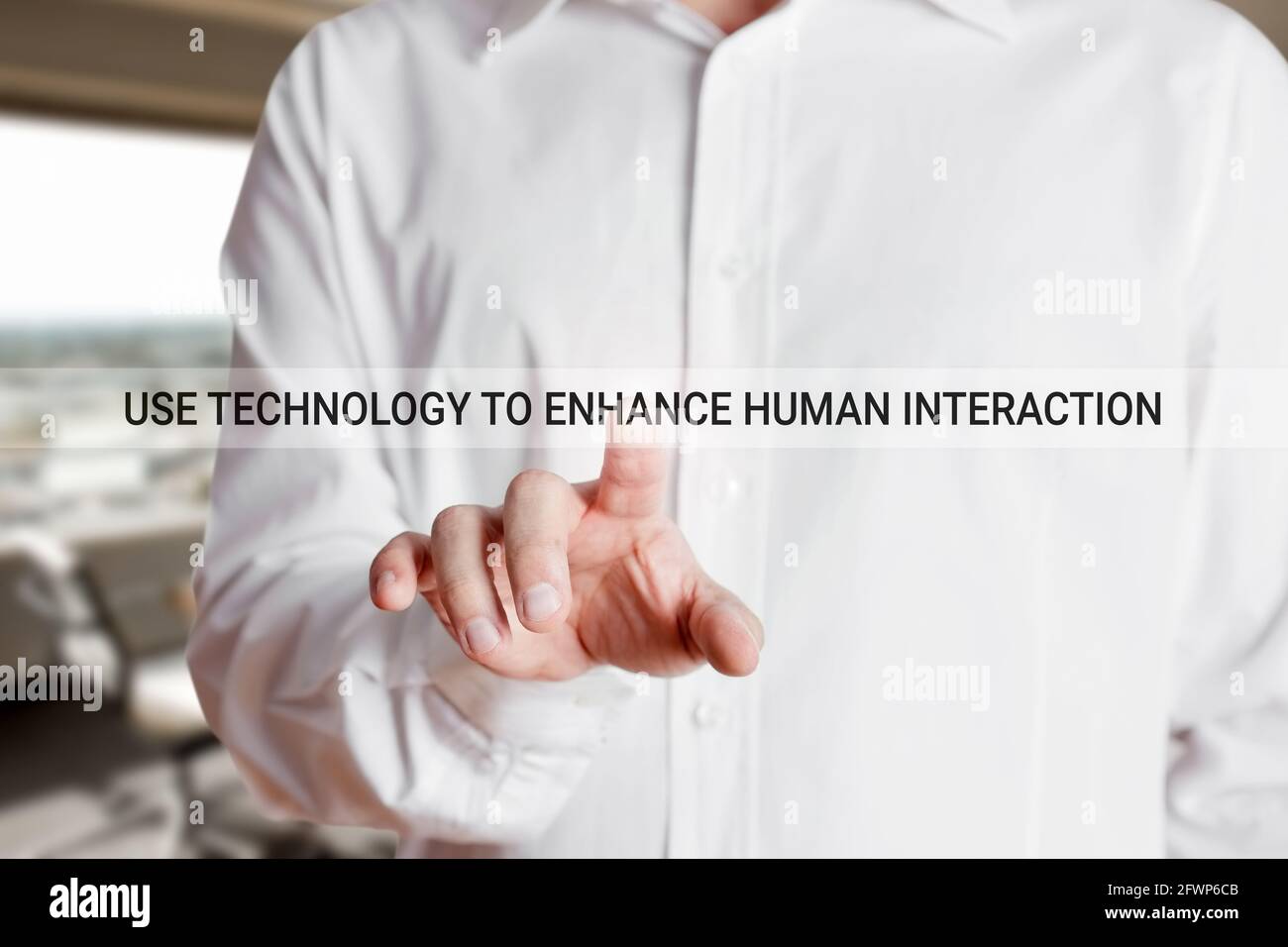 Businessman hand presses on the word use technology to enhance human interaction on a virtual touch screen. Technology and human interaction Stock Photo