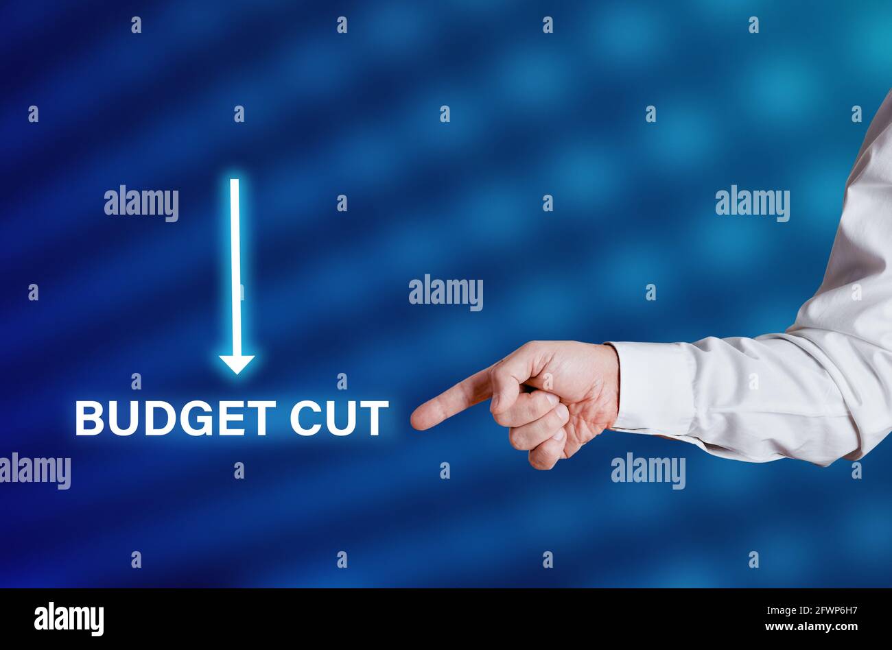 Businessman hand points to the word budget cut with arrow icon. Economic crisis and budget cuts in business concept. Stock Photo