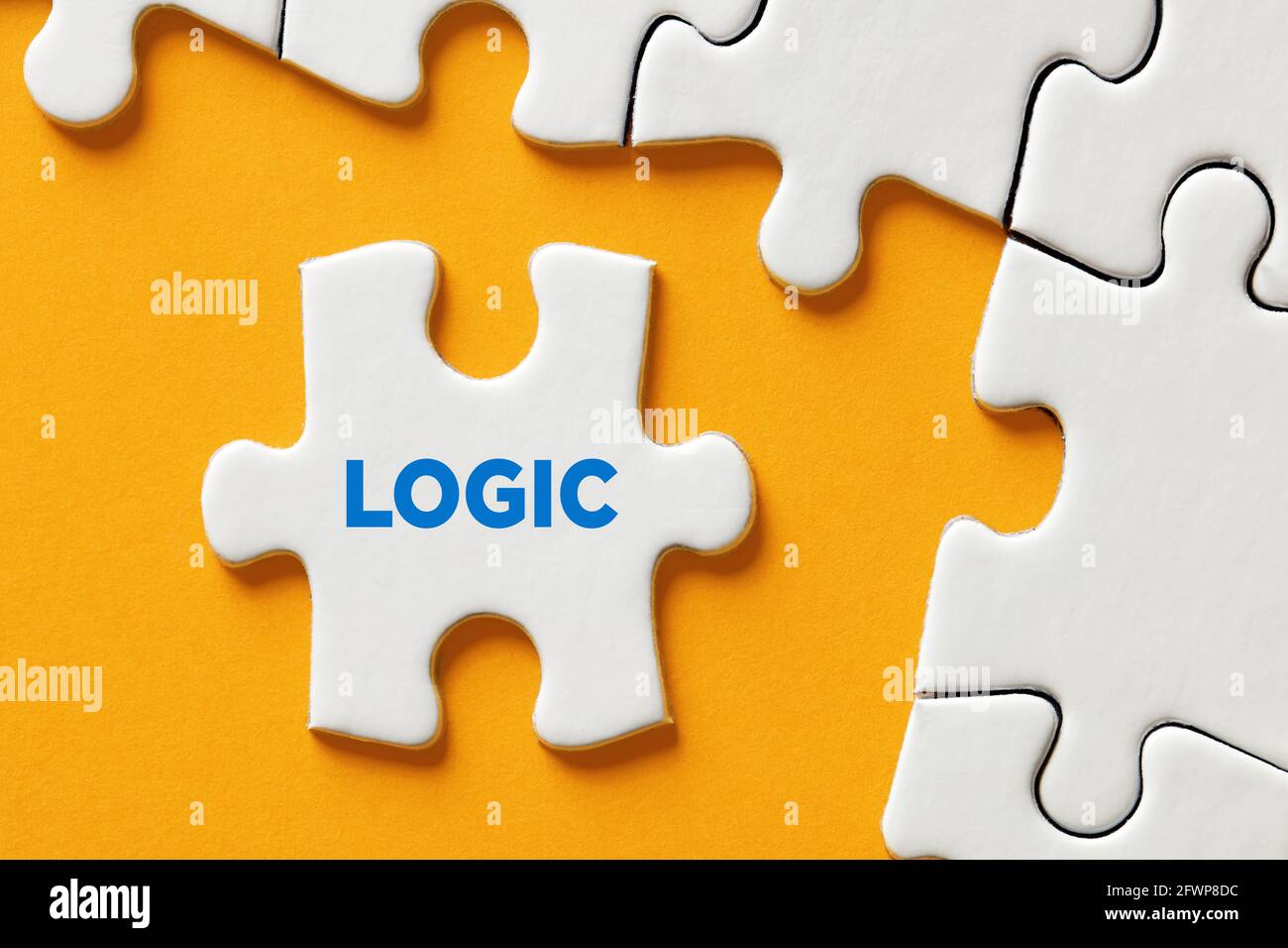 The word logic on a puzzle piece apart form the assembled pieces. Logical thinking, problem solving, cognition or attitude concept. Stock Photo