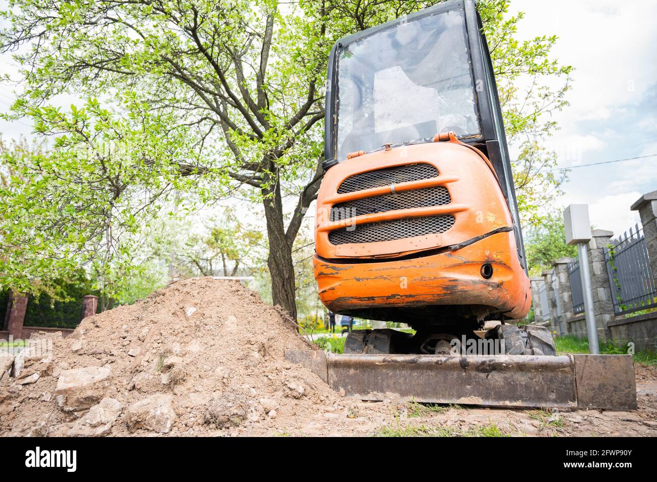 Mini excavator in orange color. construction equipment rental. Stock Photo