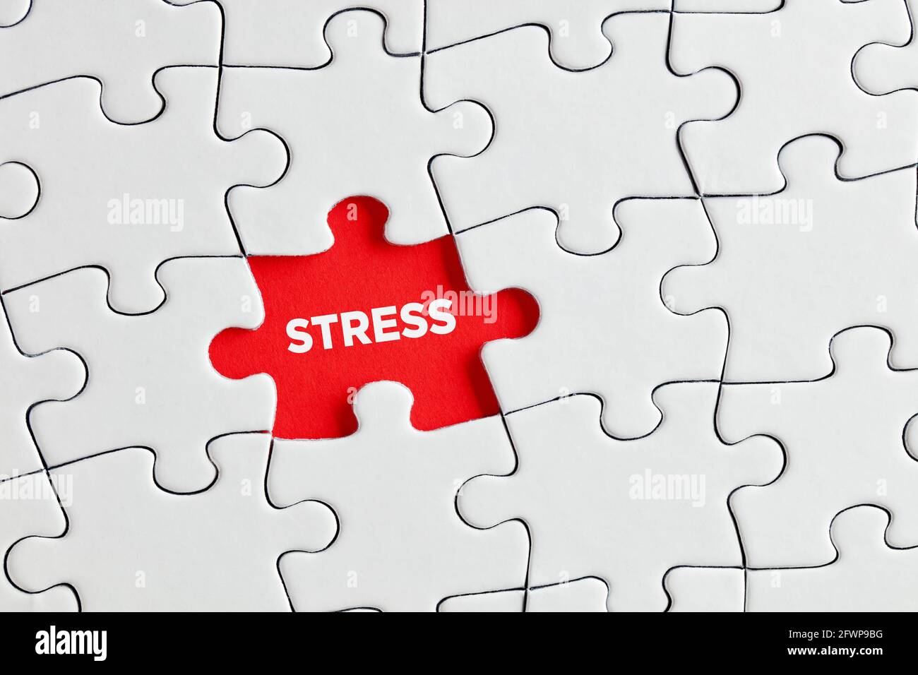 The word stress written on red missing puzzle piece. Exposing or discovering underlying stress or tension concept. Stock Photo