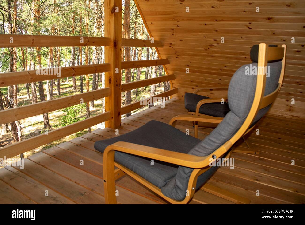 View on a forest from the balcony of a modern wooden chalet with two