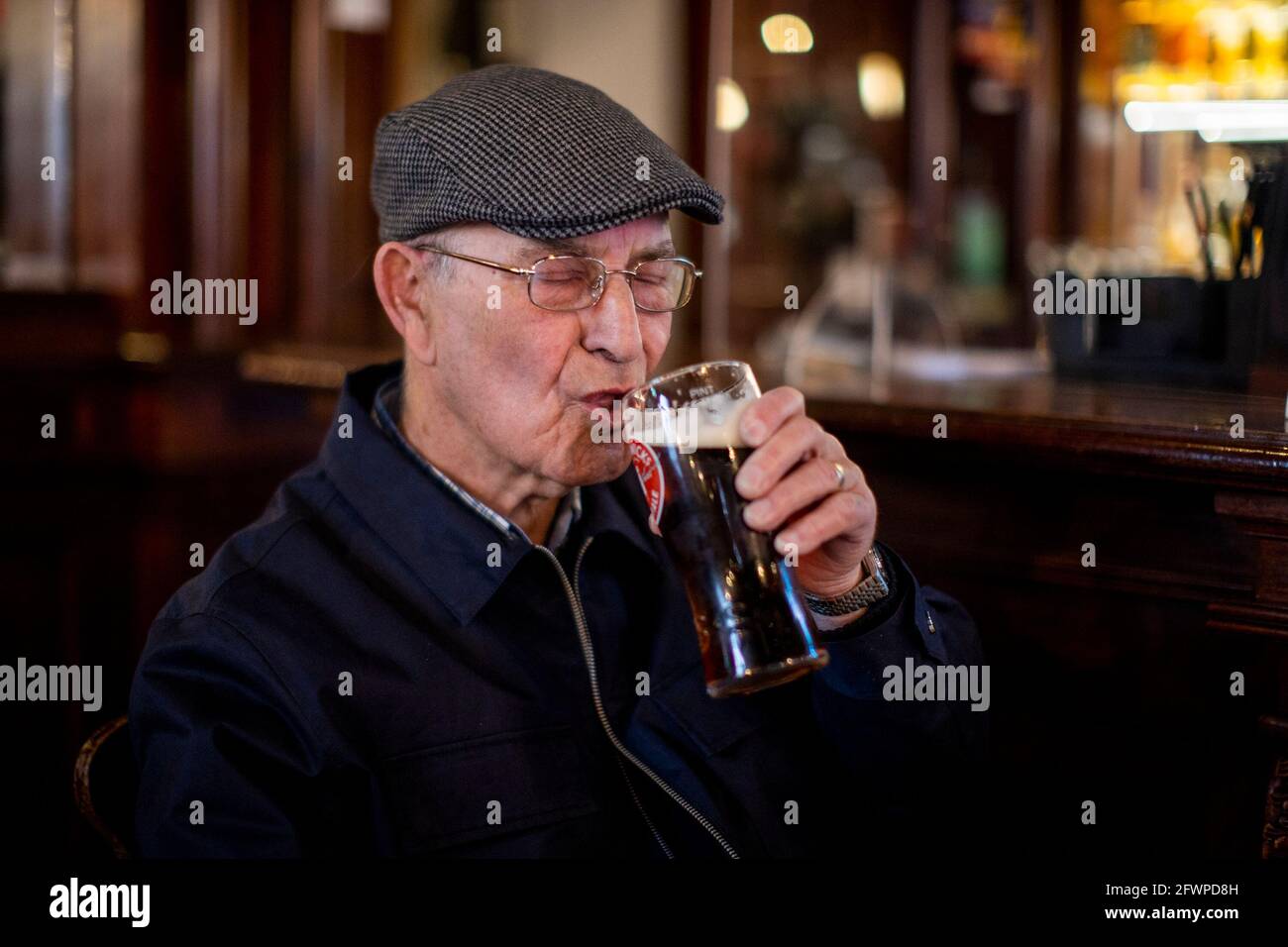 Tommy Brady, 78, enjoying his first pint of Smithwick's Ale since Christmas Eve at The Garrick Bar in Belfast, after the latest easing of the Covid-19 rules in Northern Ireland . Stock Photo