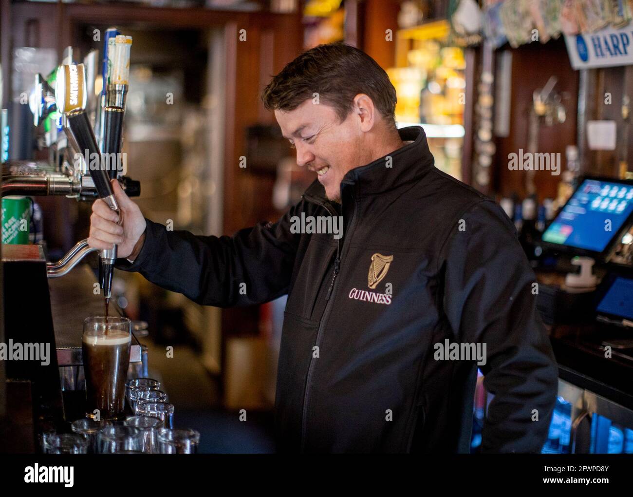 Liam Dawson, manager of The Garrick Bar in Belfast pouring a pint of Guinness after the latest easing of the Covid-19 rules in Northern Ireland. Stock Photo