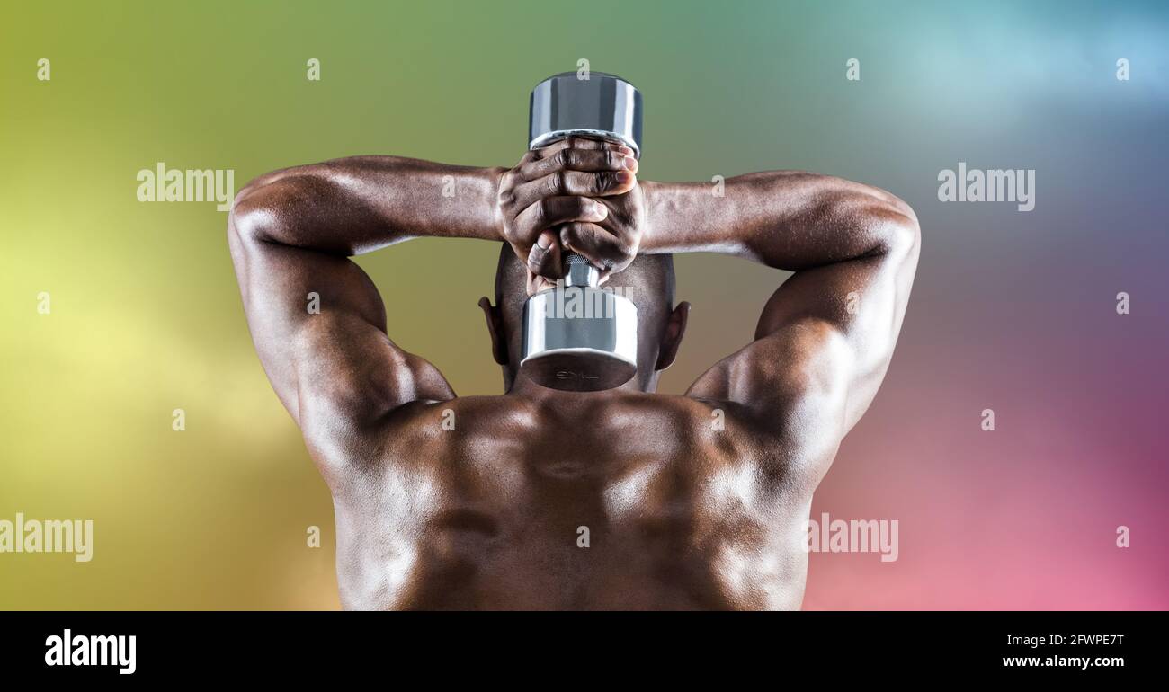 Composition of rear view of muscular strong african american man lifting dumbbells Stock Photo