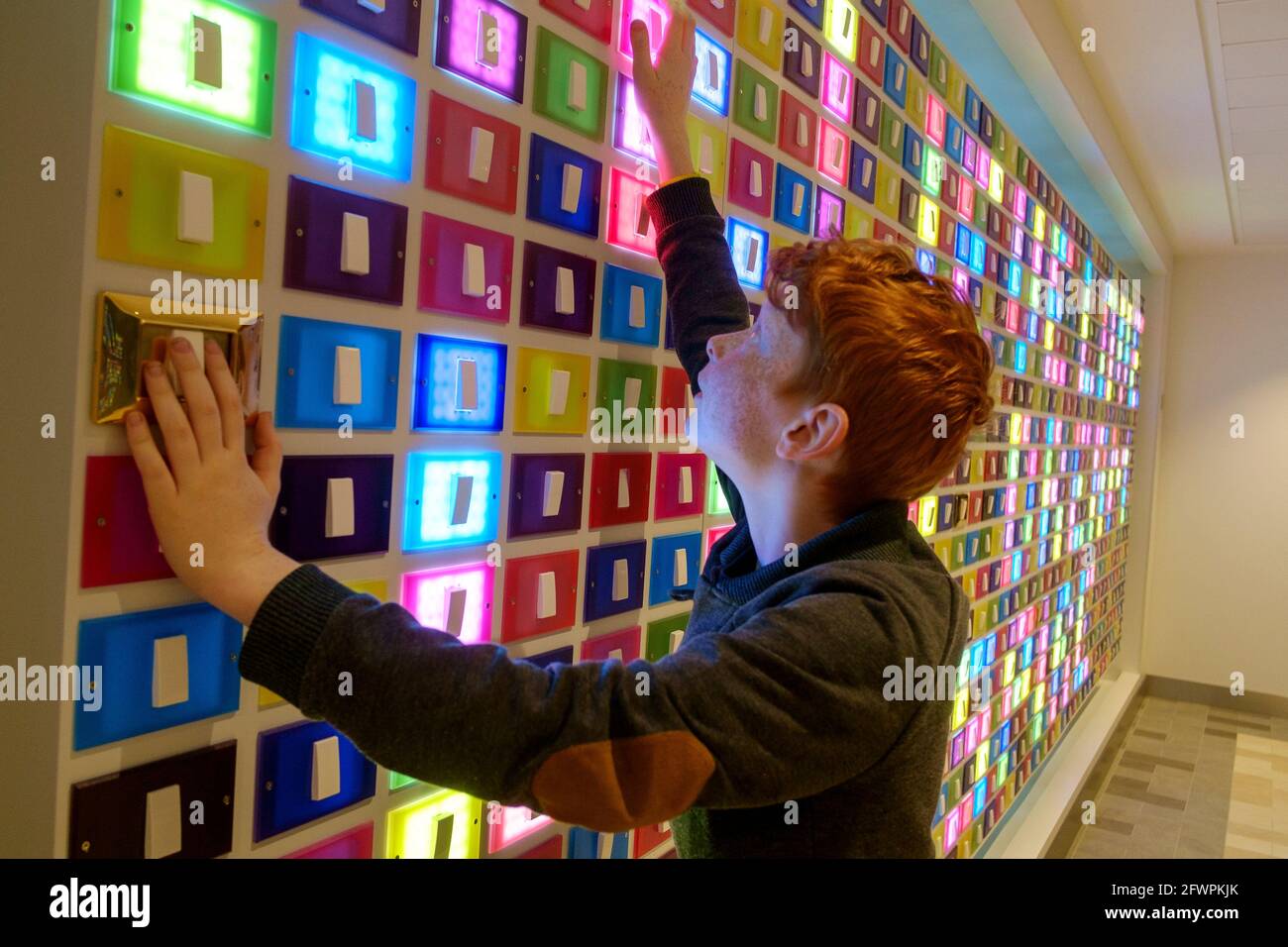 Young boy switches the lights on and off on the interactive art by Silvia Iorios on board Royal Caribbean ship Anthem of the Seas Stock Photo