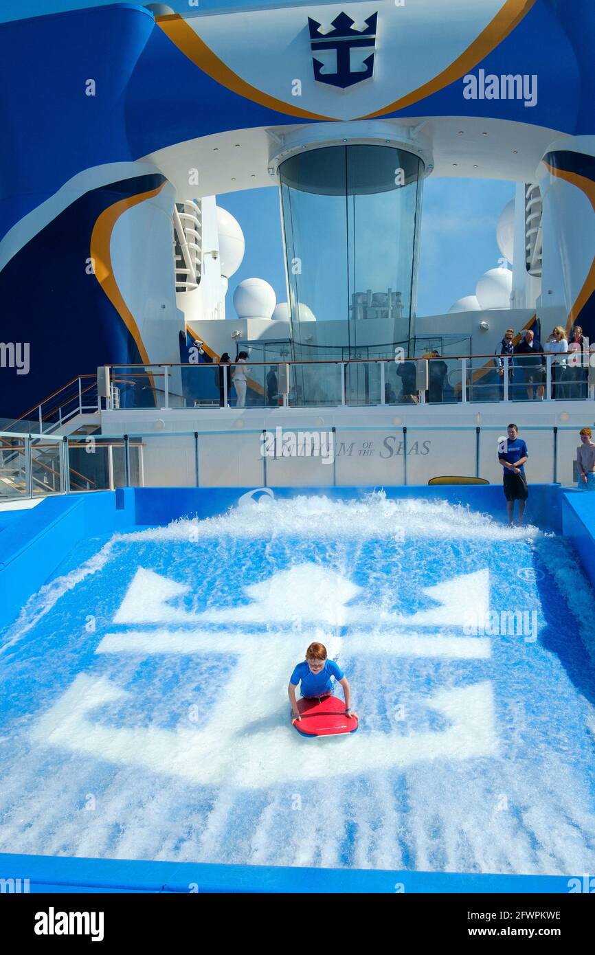 Young boy body boarding on a wave simulator on board the Royal Caribbean's ship, Anthem of the Seas. Stock Photo