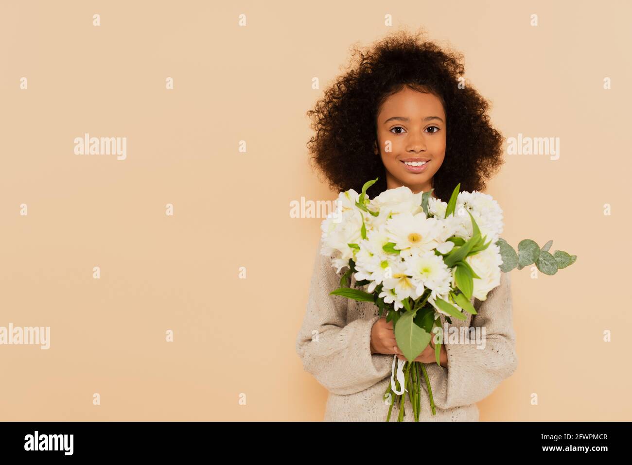 smiling african american preteen girl with bouquet of flowers in hands ...