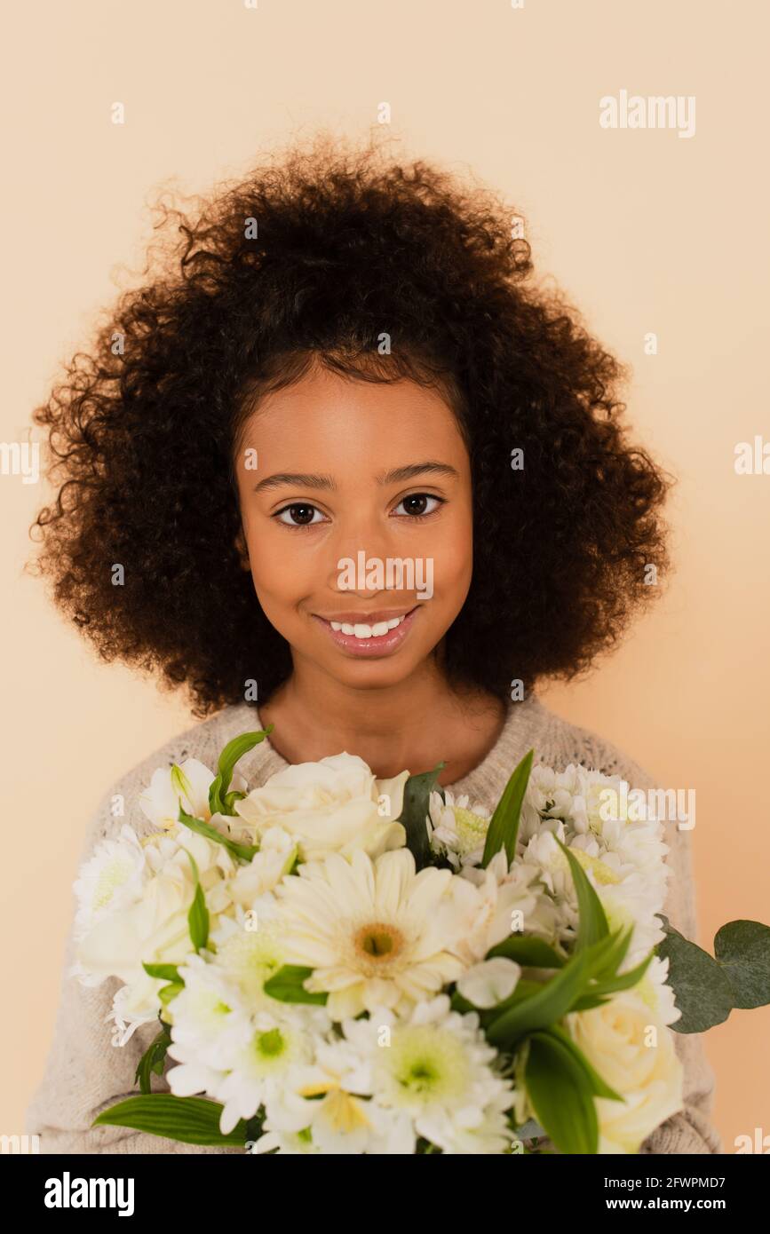 portrait of smiling african american preteen girl with bouquet of ...