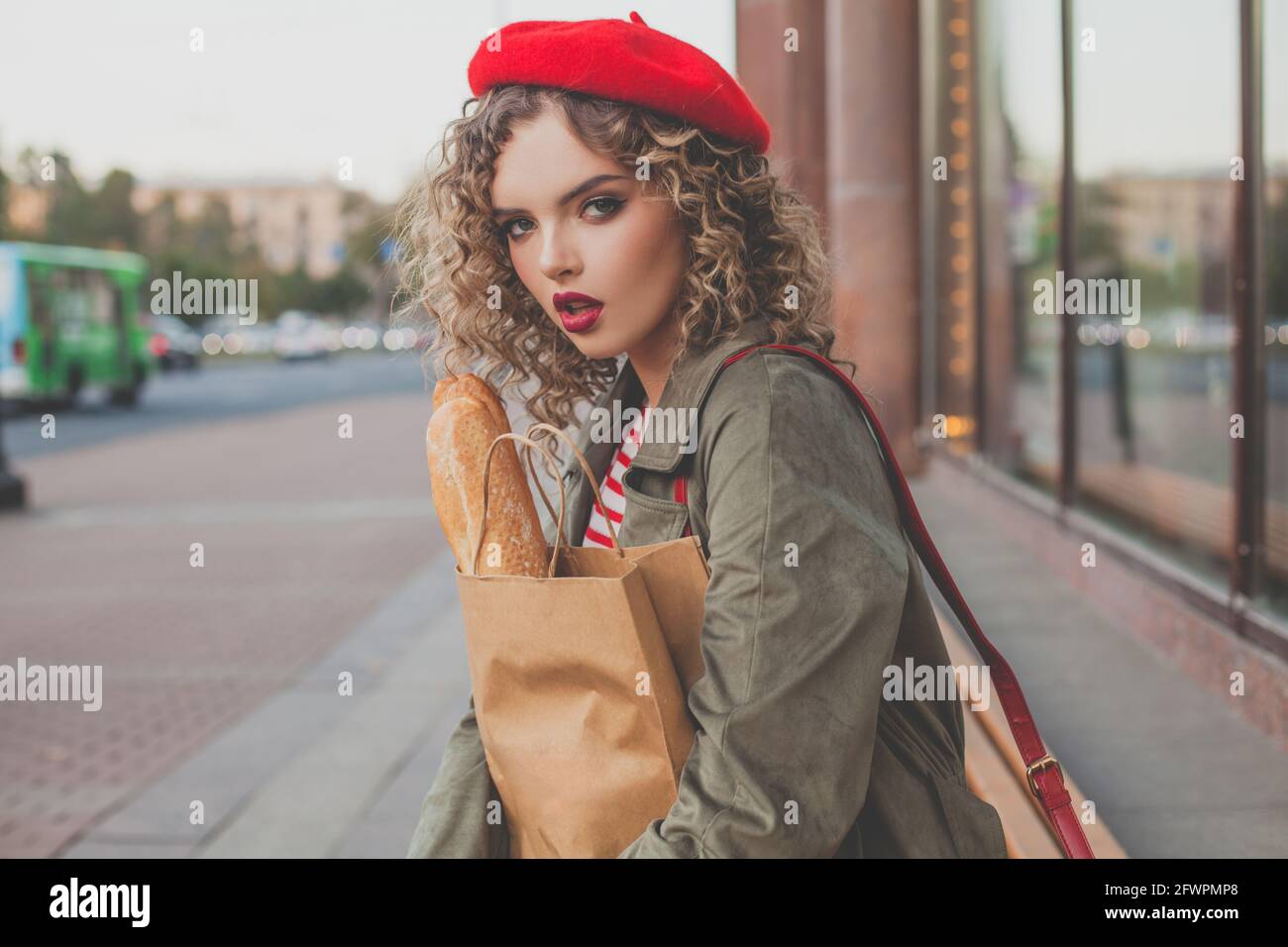 Stylish woman in red french beret holding fresh french baguette outdoor  Stock Photo - Alamy