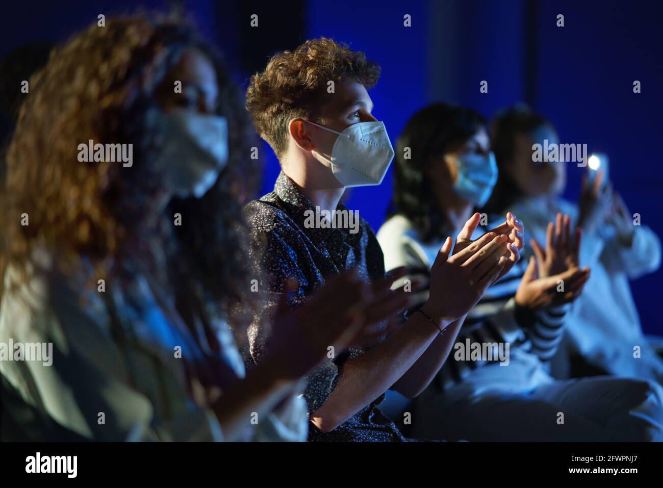 Group of people clapping while listening to presentation at conference, coronavirus concept. Stock Photo