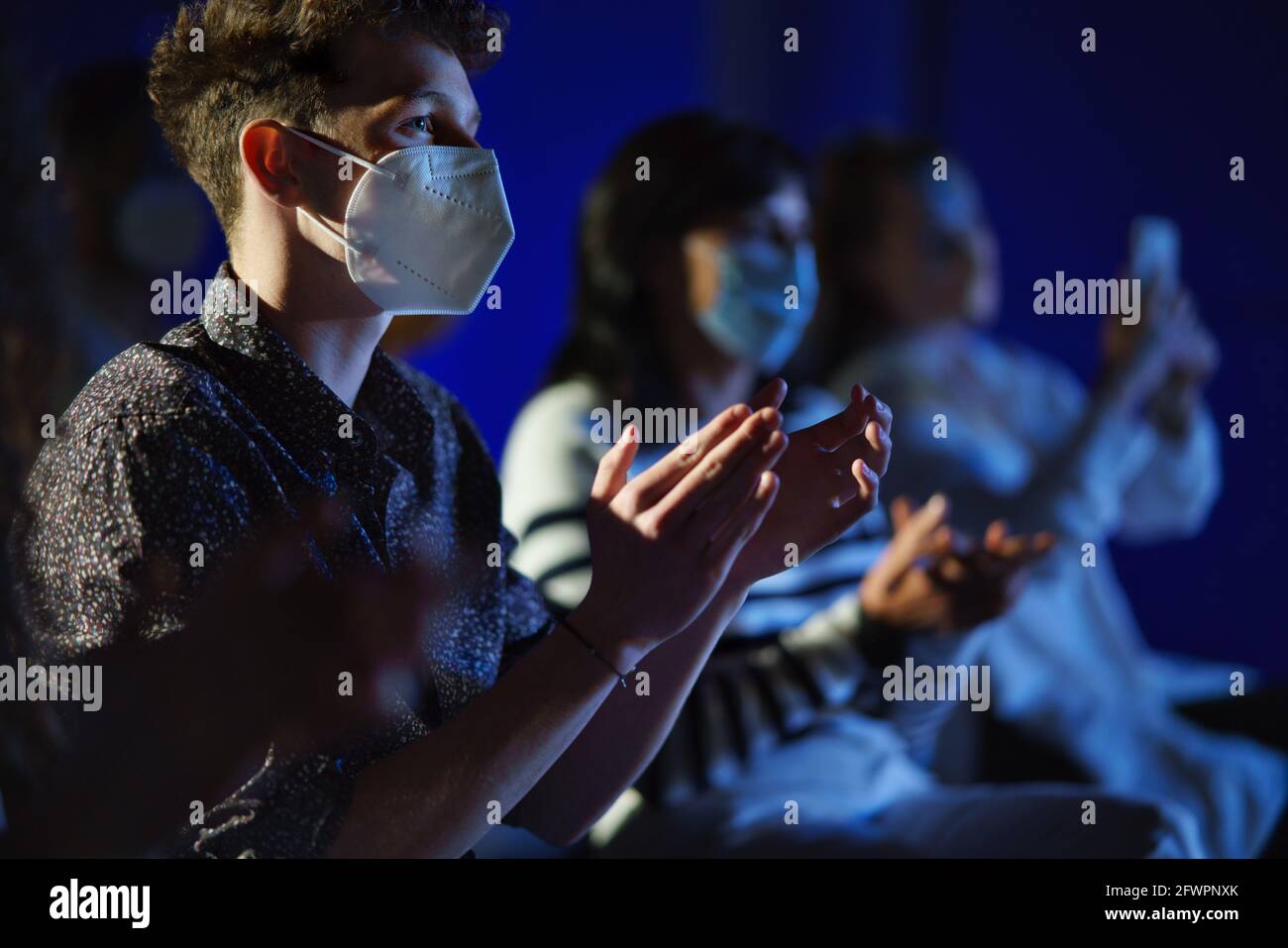 Group of people clapping while listening to presentation at conference, coronavirus concept. Stock Photo