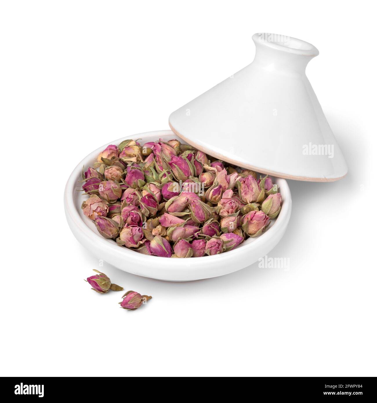 White small tajine with dried rose buds close up isolated on white background Stock Photo
