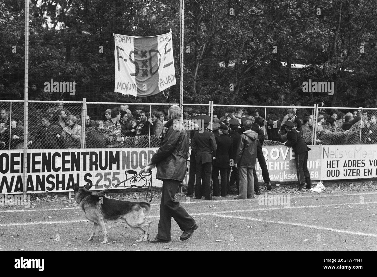 Ajax supporters behind destroyed fences with police in front, October 9, 1983, policemen, riots, sniffer dogs, supporters, soccer, matches, The Netherlands, 20th century press agency photo, news to remember, documentary, historic photography 1945-1990, visual stories, human history of the Twentieth Century, capturing moments in time Stock Photo