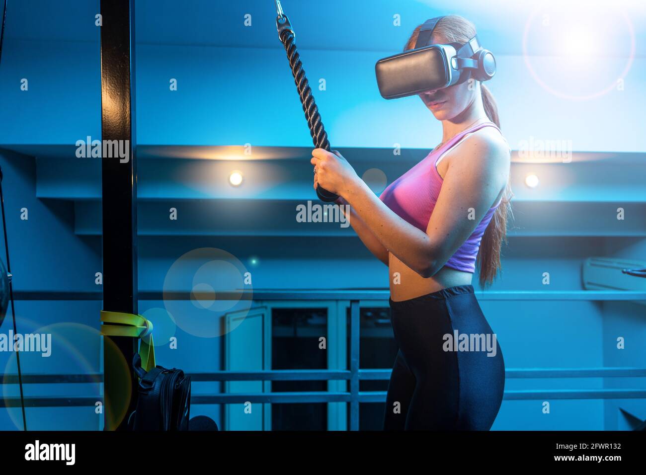 Attractive young red hair sportswoman training triceprs in the gym of her beautiful house with vr futuristic goggles - Ginger athletic model doing hom Stock Photo