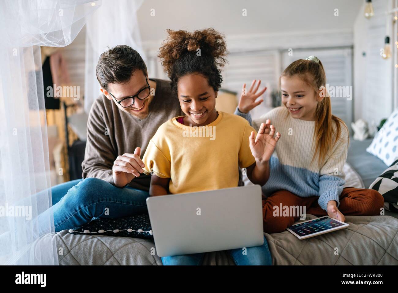 People, family and technology concept. Happy father with multiethnic children having fun together Stock Photo