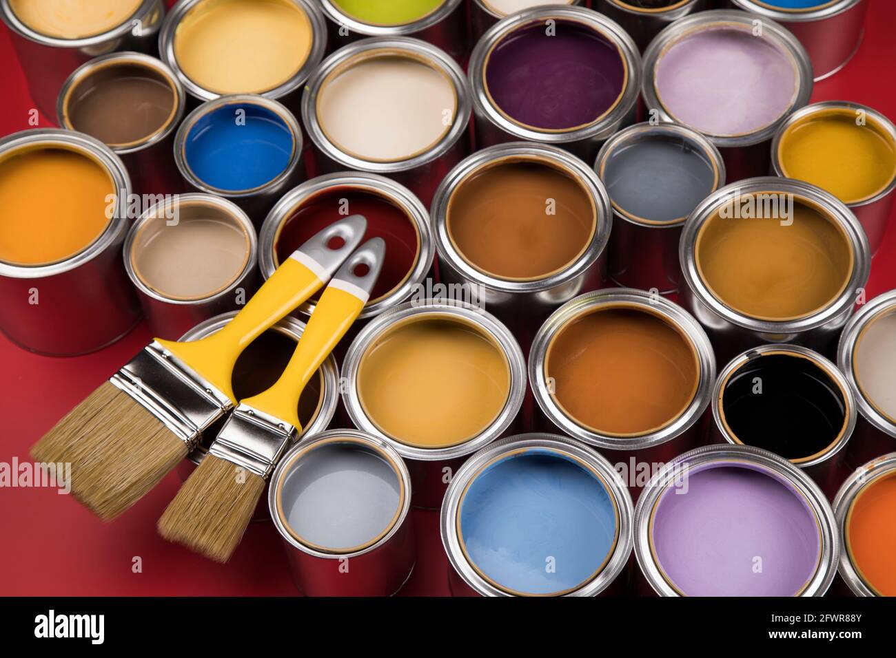 Close-up of red paint brushes in a metal jar. Stock Photo by puhimec