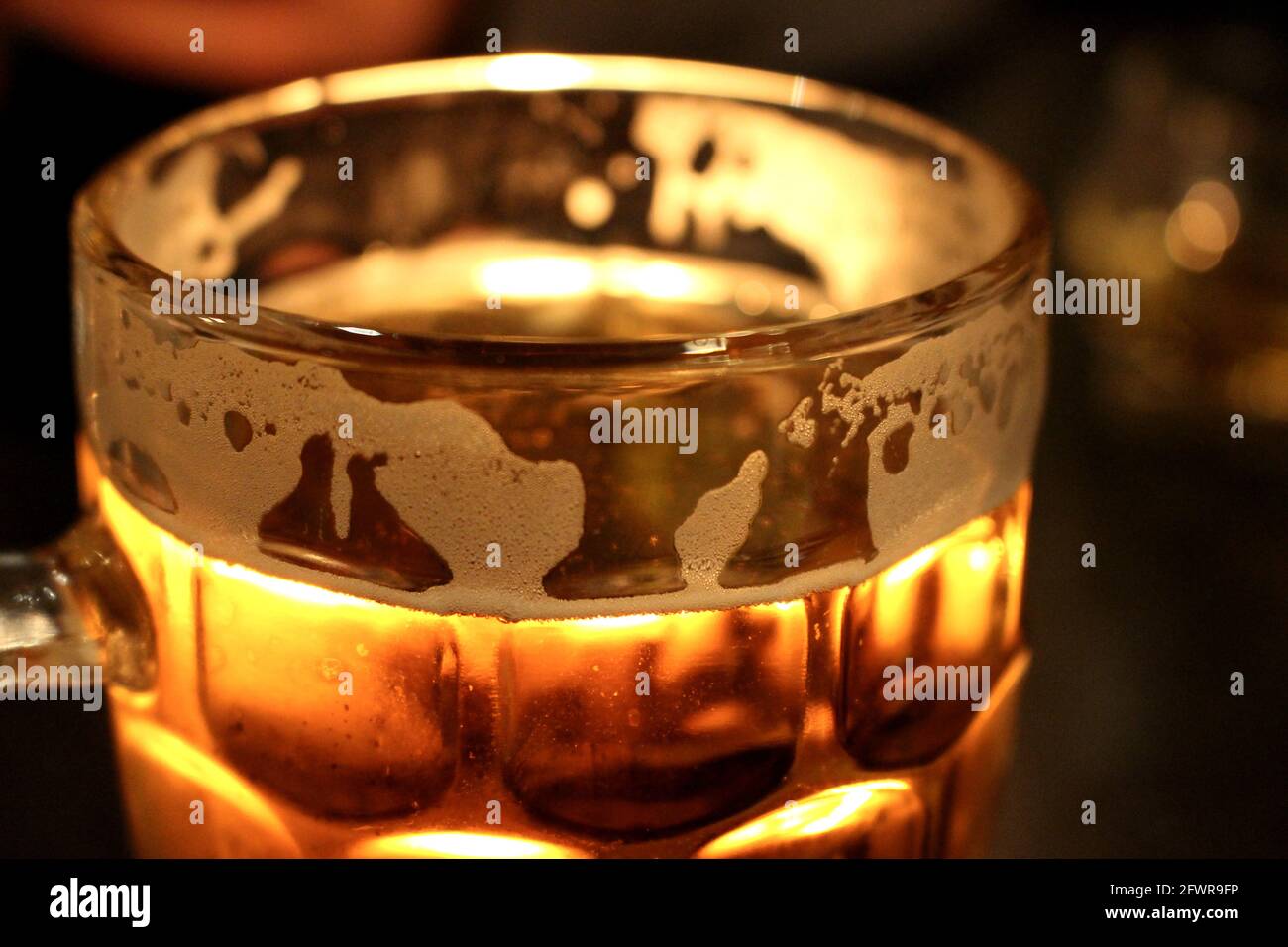 A mug of beer illuminated by a candle Stock Photo