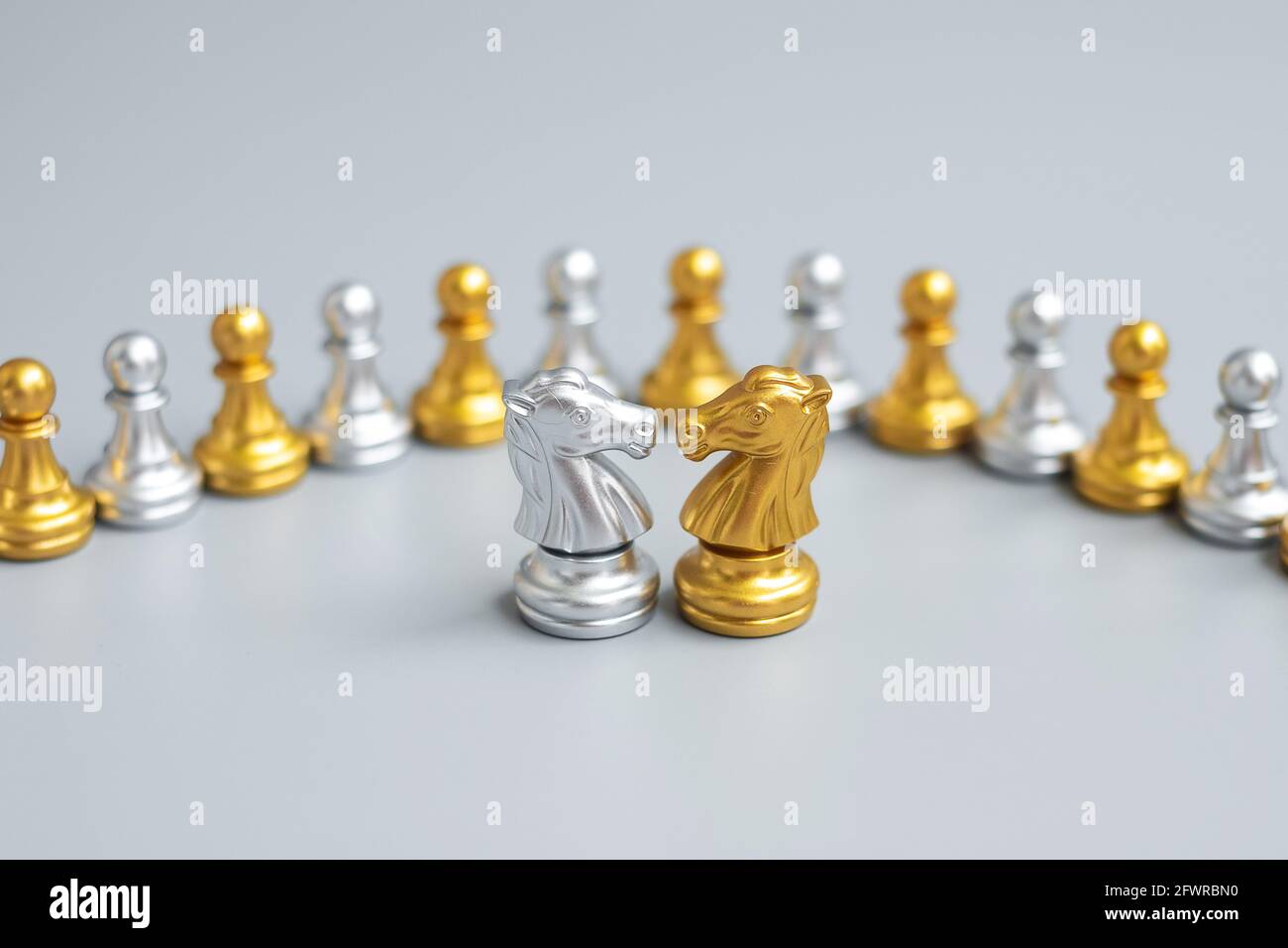 Gold and silver Chess Knight (horse) figure against pawn. Strategy, Conflict, management, business planning, tactic, politic, communication and leader Stock Photo